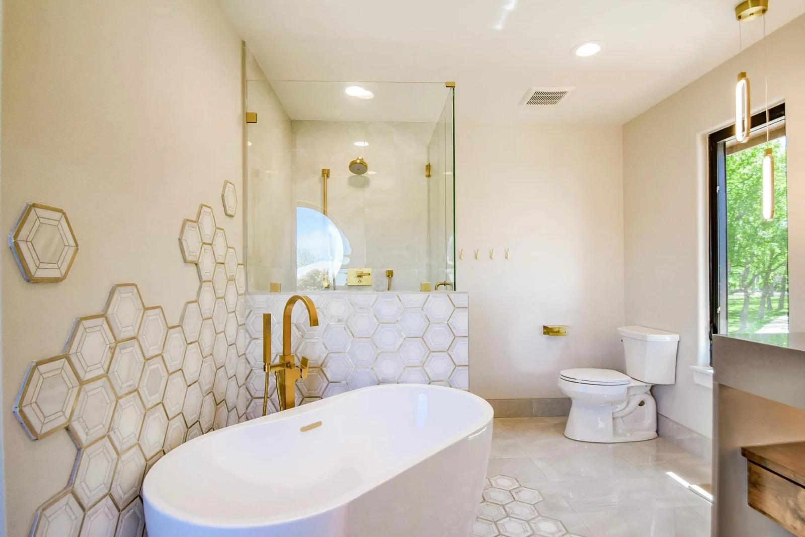 White bathtub with gold fixtures and decorative hexagon tile